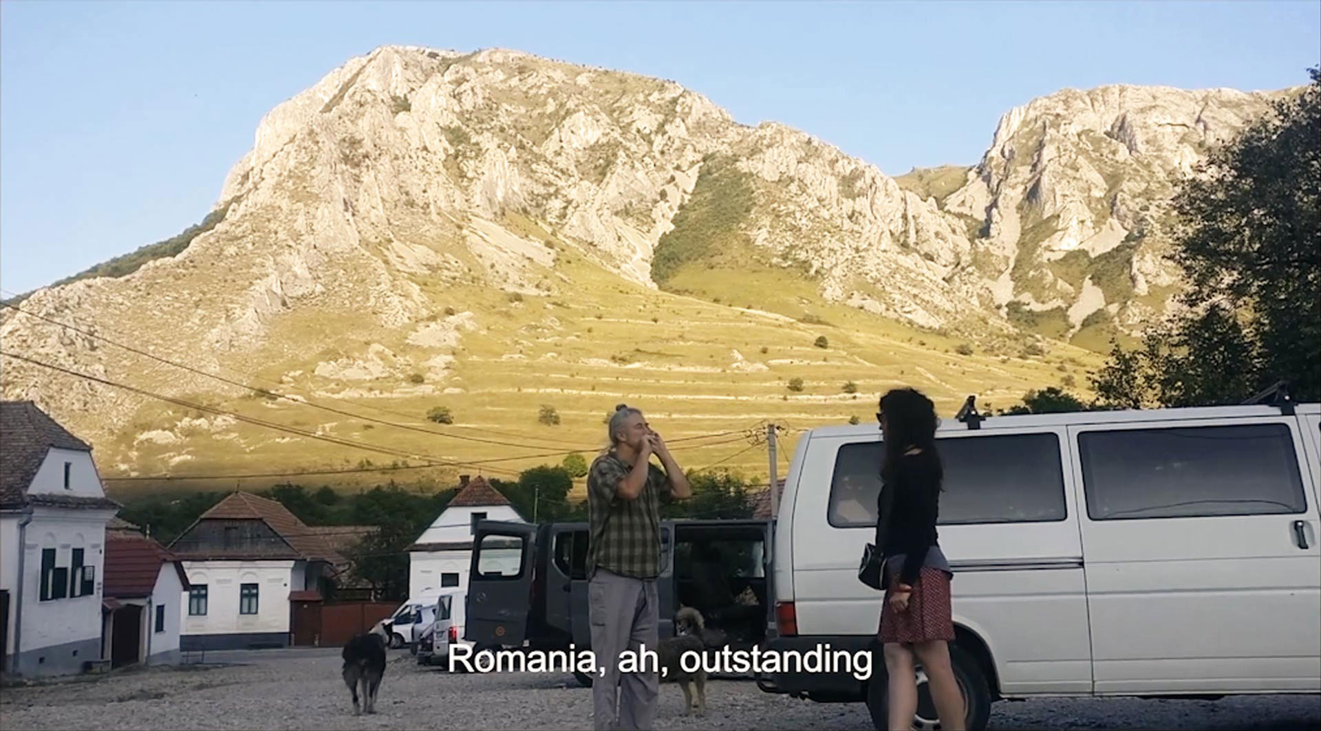 our hosts in front of a sunny Romanian landscape